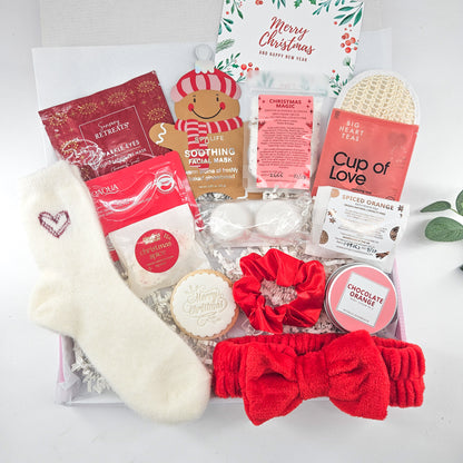 Christmas Luxury Edit gift box with gingerbread face mask, fluffy heart socks, festive skincare, shower steamers, bath treats and red spa accessories