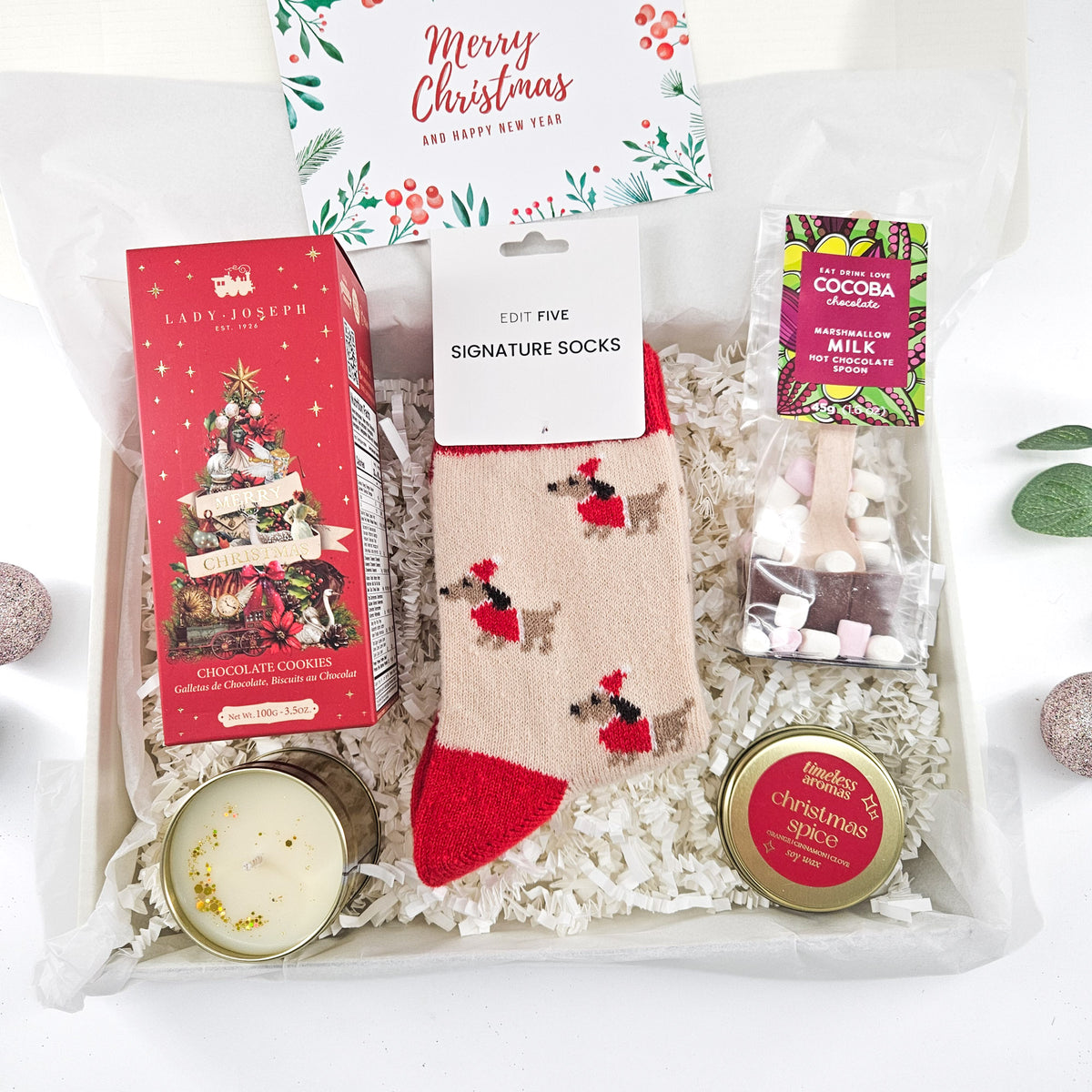 Cosy Christmas gift set for her with chocolate Christmas tree, wool socks, hot chocolate spoon and festive candle.