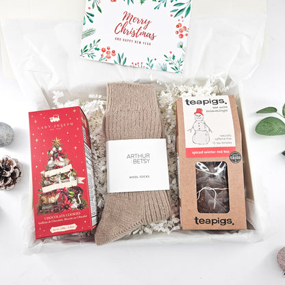 Cosy Christmas tea and biscuits gift box with wool socks, Teapigs spiced winter tea, festive chocolate cookies and a greeting card.