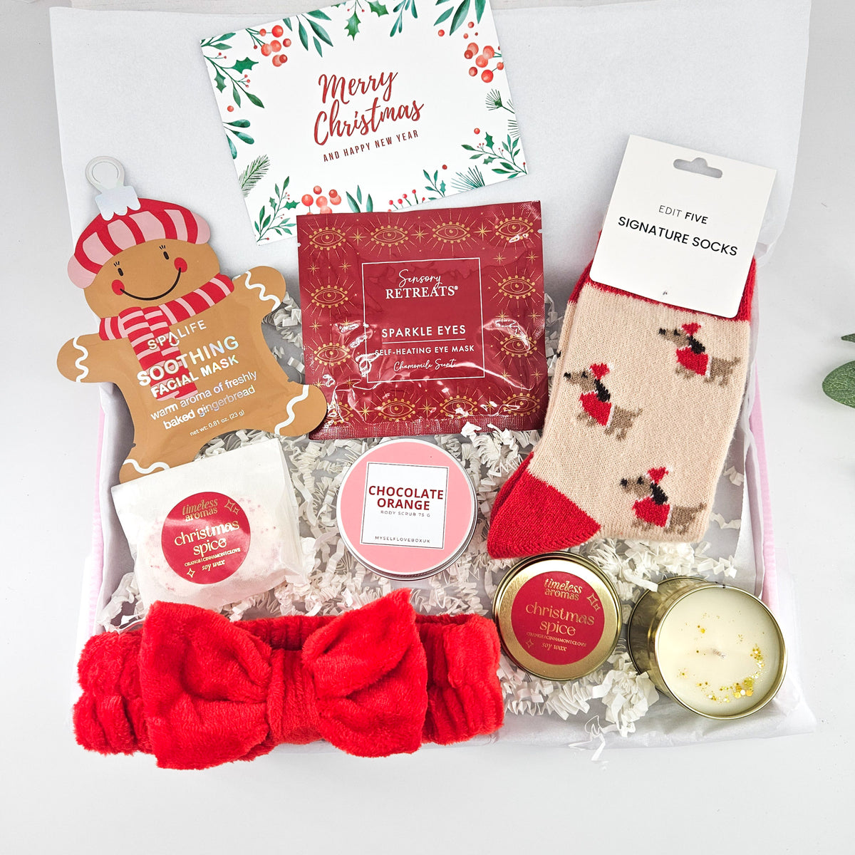 Festive Feel-Good Christmas care package for her with reindeer socks, gingerbread face mask, red spa headband, body scrub and candle