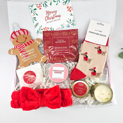 Festive Feel-Good Christmas care package for her with reindeer socks, gingerbread face mask, red spa headband, body scrub and candle