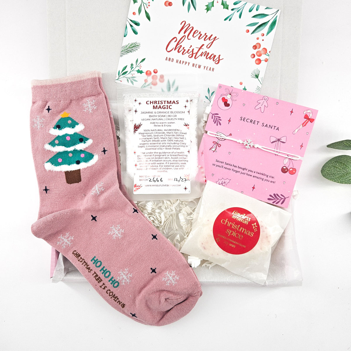 Secret Santa Christmas letterbox gift with pink Christmas tree socks, Christmas Magic bath soak, wish bracelet and Christmas Spice wax melts