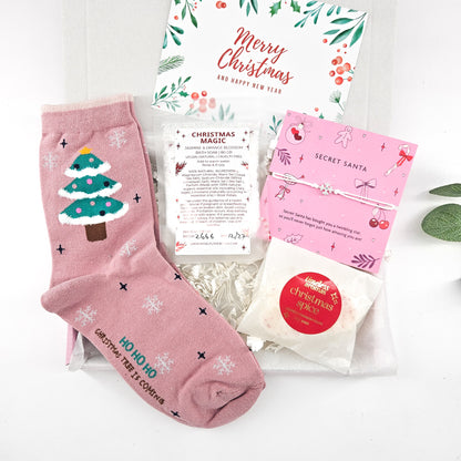 Secret Santa Christmas letterbox gift with pink Christmas tree socks, Christmas Magic bath soak, wish bracelet and Christmas Spice wax melts